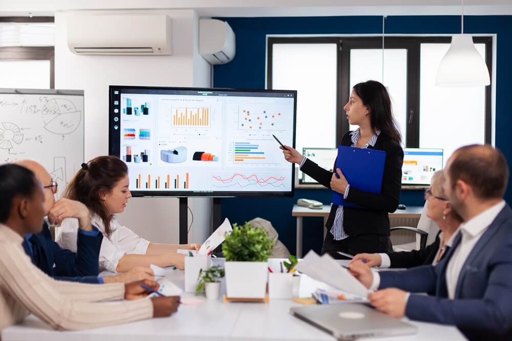 a lady presenting in front of business team